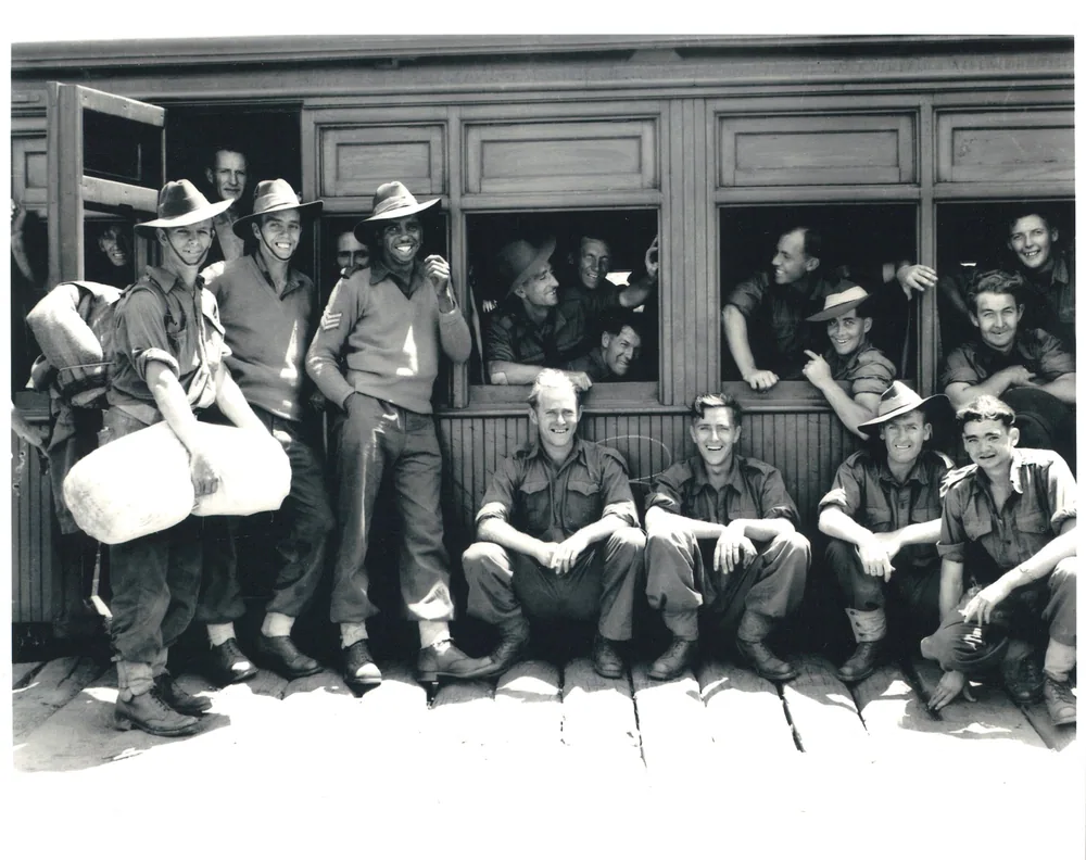 Servicemen photographed at a train window.