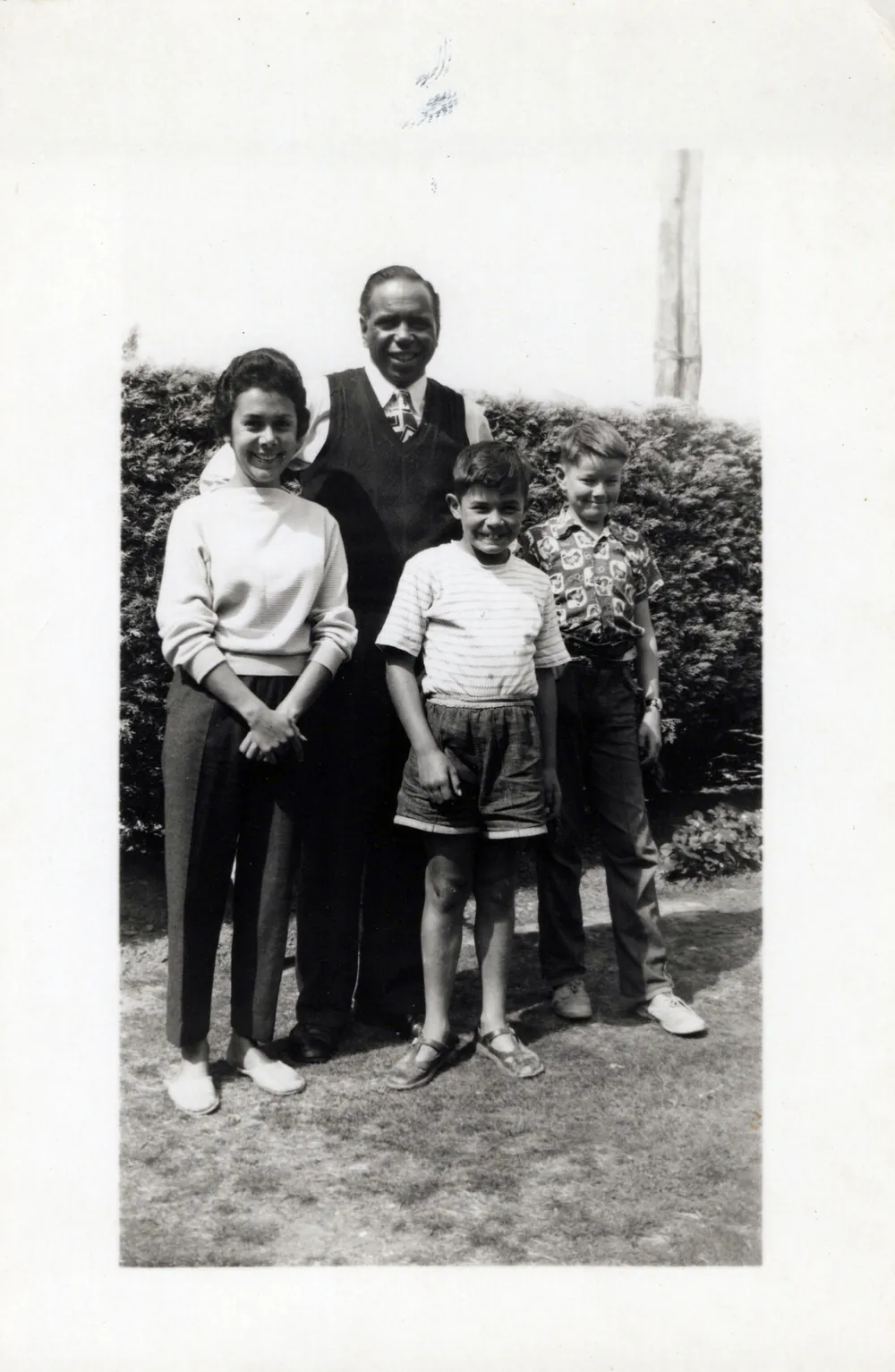 Family group beside a hedge.