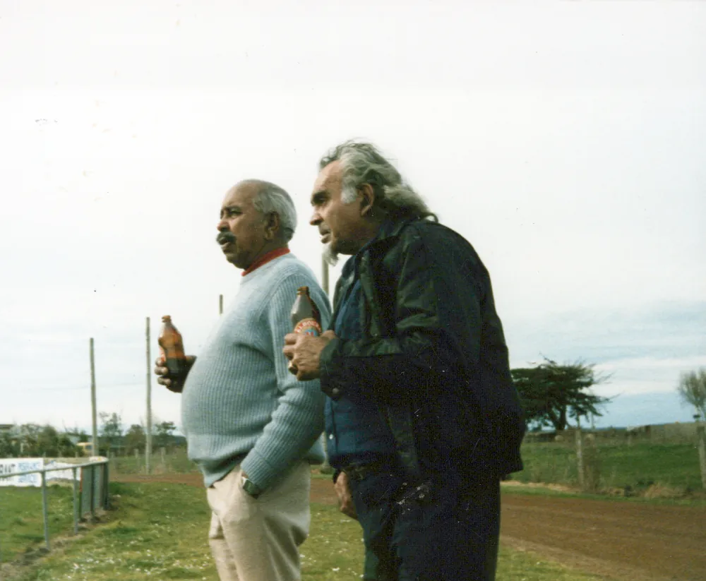 Two men talking in a paddock.