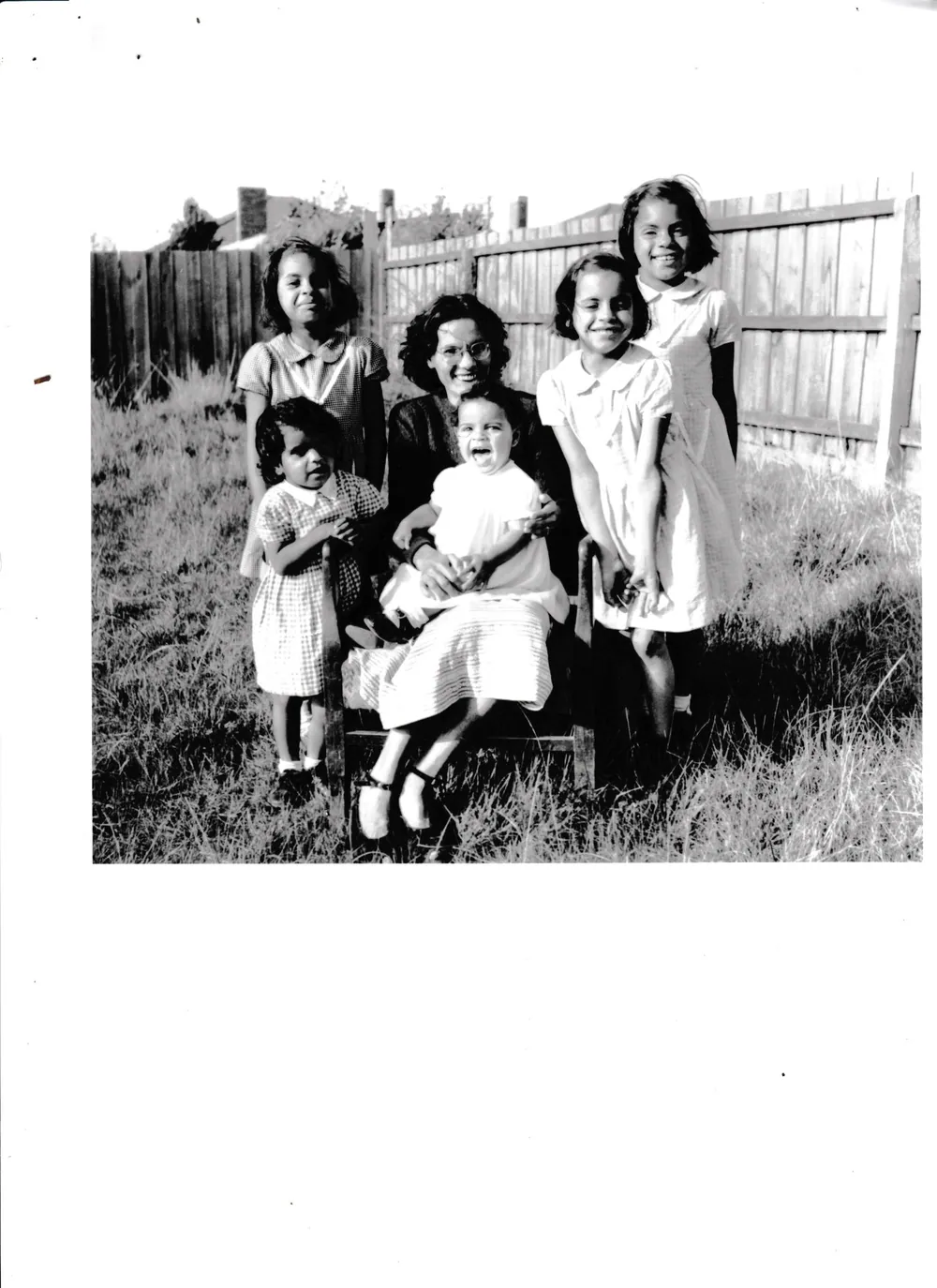 Family photograph of children in a backyard.