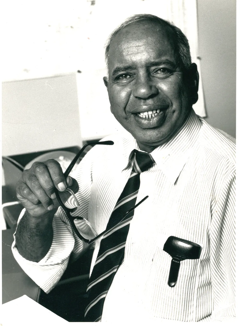 Portrait in shirt and tie, holding a pipe.