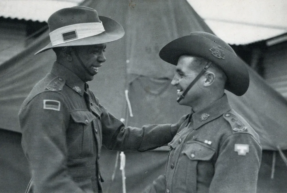An officer decorating a soldier in a slouch hat.